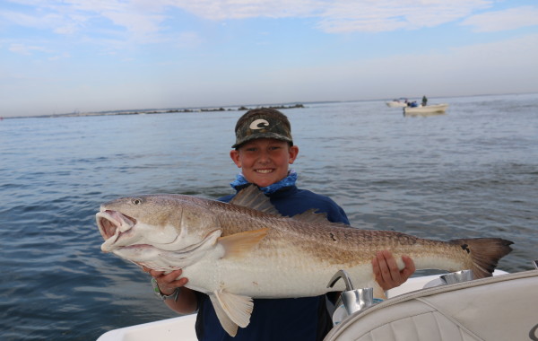 Young angler with a monster Red Fish