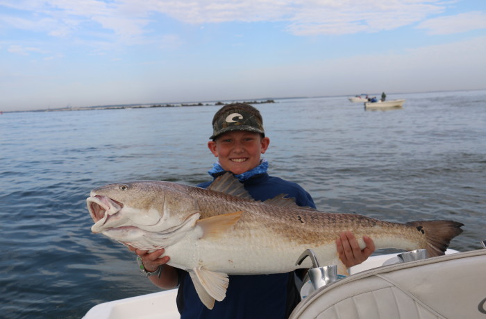 Young angler with a monster Red Fish
