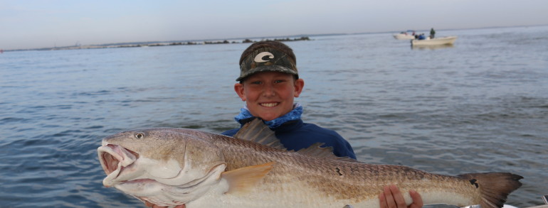 Young angler with a monster Red Fish