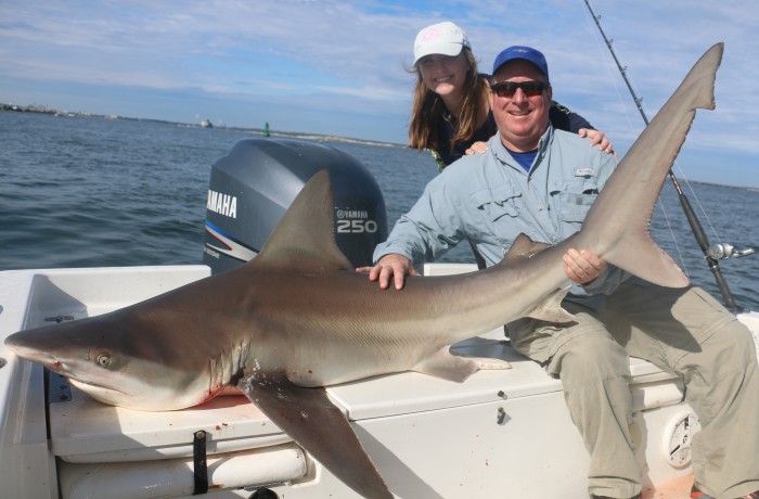 Father and daughter taming a toothy critter